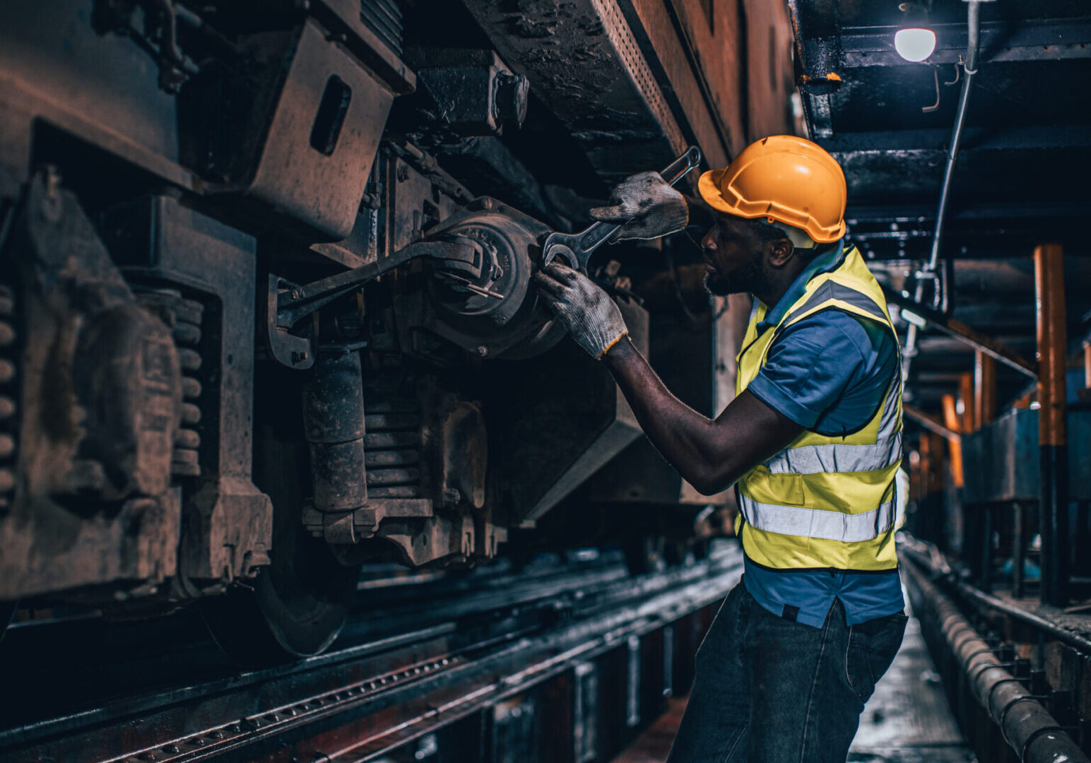 one man worker servicing replace broken part of old train at diesel locomotive repair shops